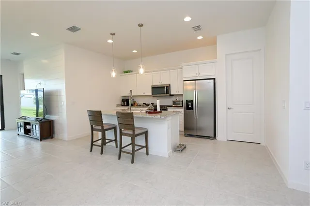a kitchen with refrigerator and chairs