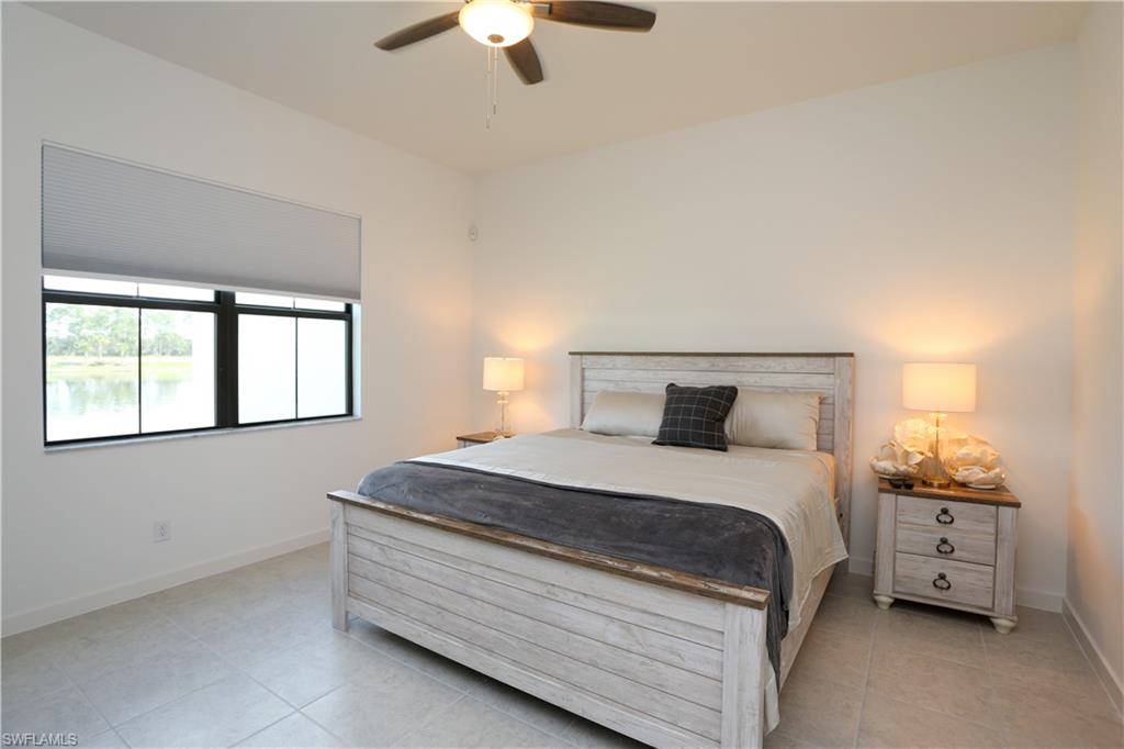 14759 Kingfisher Loop Naples, FL 34120 - Photo 16 of 35 a bedroom with a bed and a chandelier