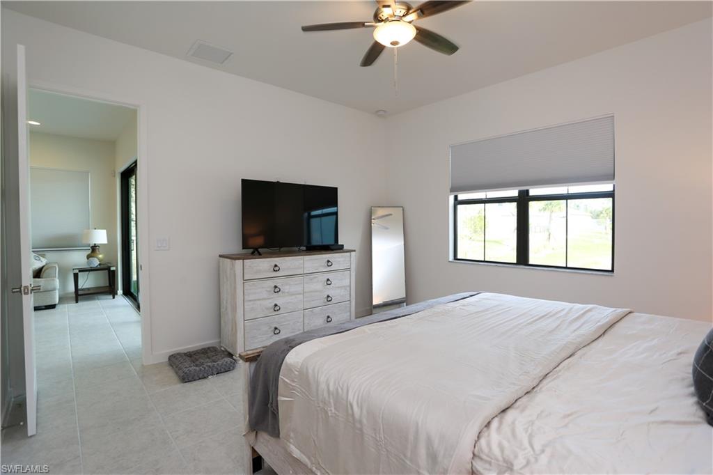 14759 Kingfisher Loop Naples, FL 34120 - Photo 19 of 35 a bedroom with a bed and a flat screen tv