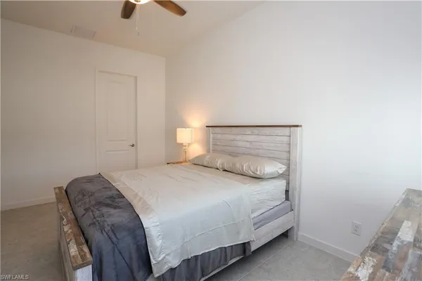 a bedroom with a bed and a ceiling fan