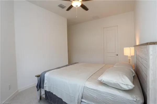 a bedroom with a bed and a ceiling fan