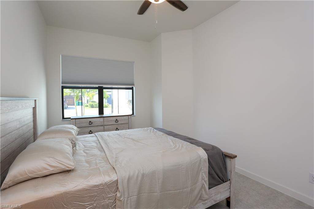 14759 Kingfisher Loop Naples, FL 34120 - Photo 28 of 35 a bedroom with a bed and a chandelier