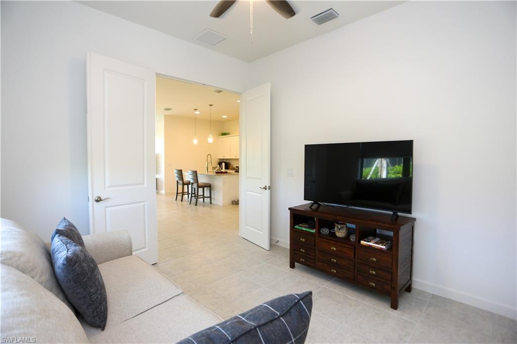 14759 Kingfisher Loop Naples, FL 34120 - Photo 30 of 35 a living room with furniture and a flat screen tv