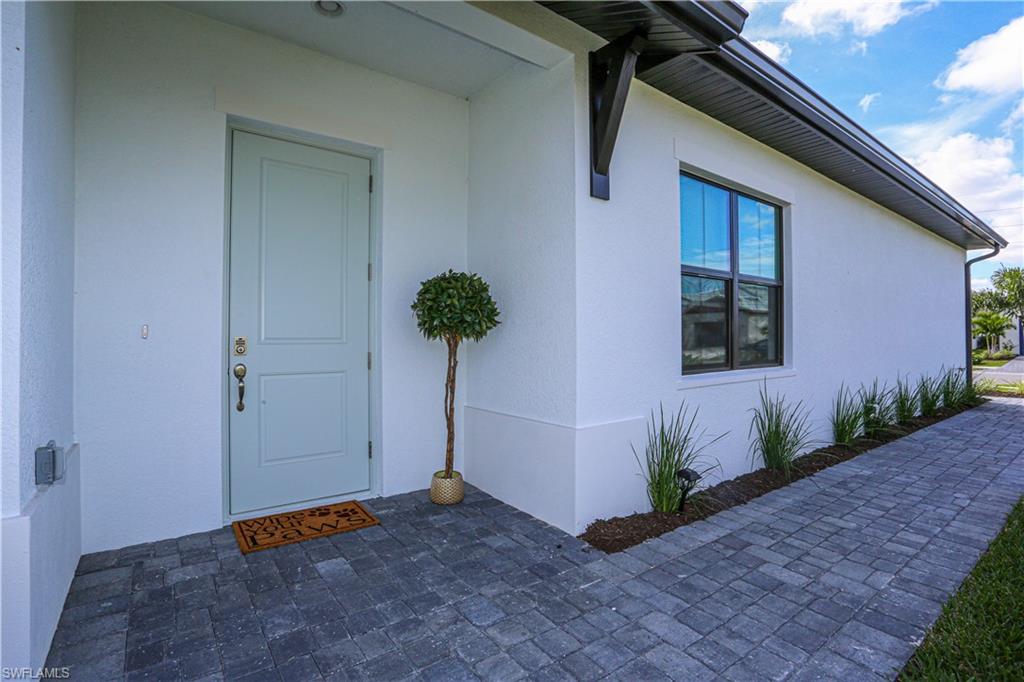 14759 Kingfisher Loop Naples, FL 34120 - Photo 4 of 35 a view of an entryway of house with potted plants