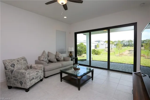 a living room with furniture and a floor to ceiling window