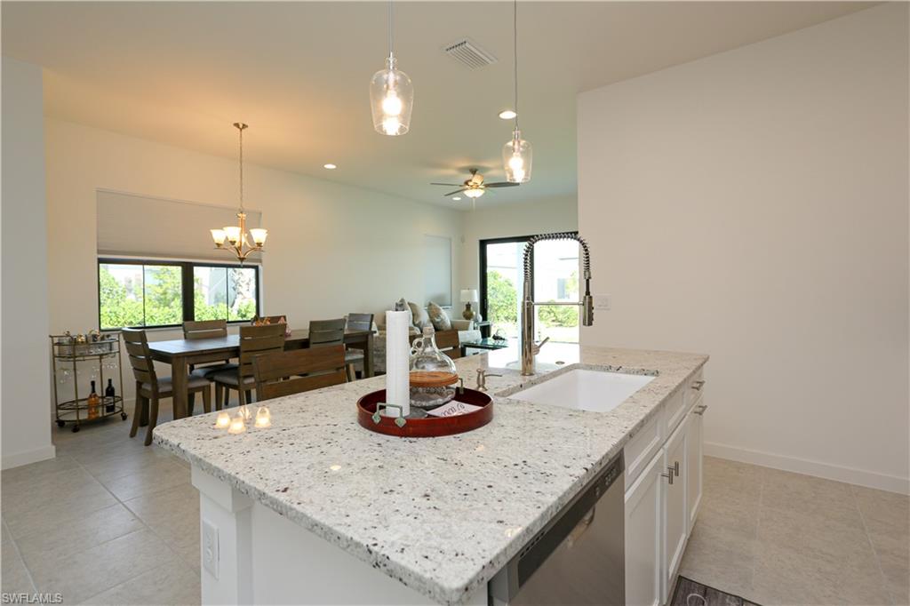 14759 Kingfisher Loop Naples, FL 34120 - Photo 10 of 35 a kitchen with a counter space a sink and living room view