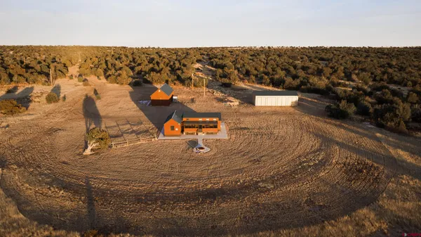 a open kitchen with stainless steel appliances granite countertop a stove top oven a dining table and chairs with wooden floor