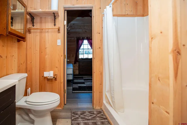 a open kitchen with stainless steel appliances granite countertop a stove top oven a dining table and chairs with wooden floor