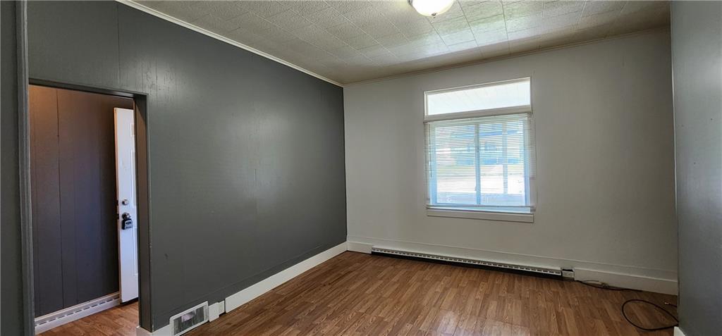 631 Reed Avenue Monessen, PA 15062 - Photo 5 of 12 an empty room with wooden floor and windows