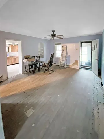 a view of a livingroom with lounge chair and windows