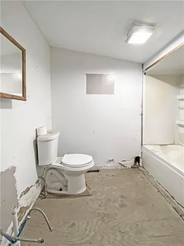 a white toilet sitting next to a bathroom sink and tub