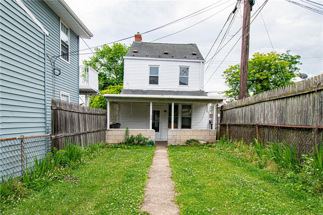 27 West Allen Street Allentown, PA 18102 - Photo 25 of 26 A classic two-story residence with a charming front porch, surrounded by lush green lawn and privacy fencing.
