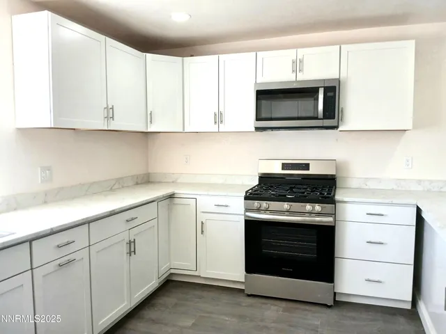 a kitchen with white cabinets and stainless steel appliances
