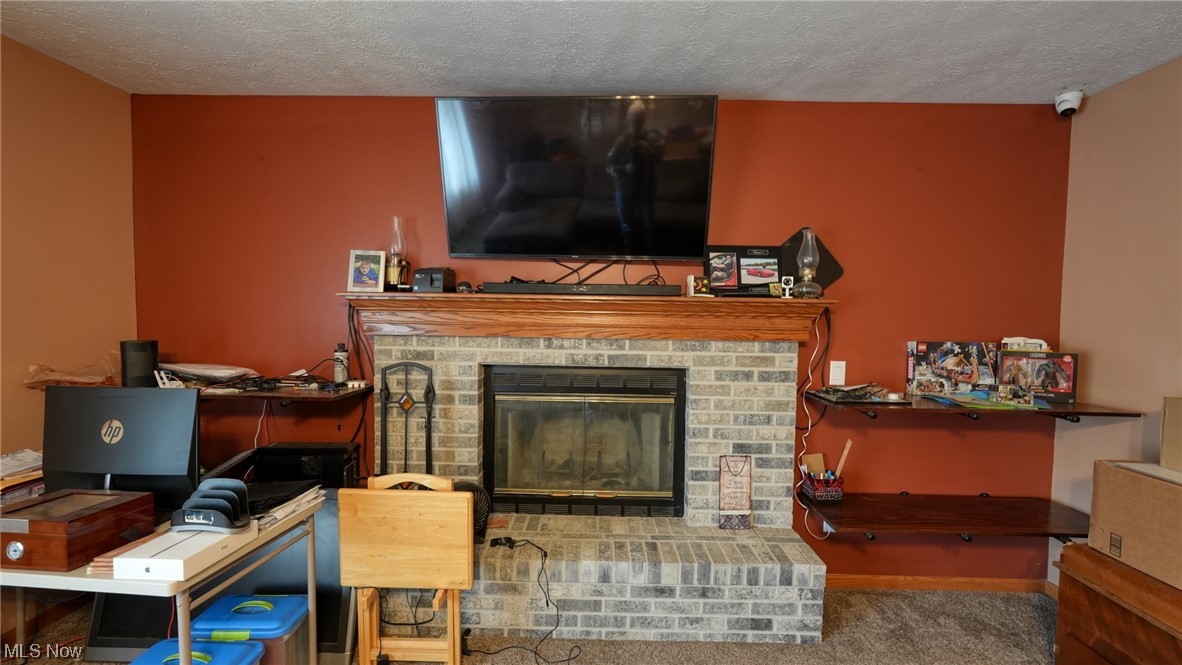 3752 Holmes Road Cambridge, OH 43725 - Photo 15 of 50 Carpeted living room with a brick fireplace and a textured ceiling