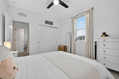 a bedroom with a large bed and ceiling fan