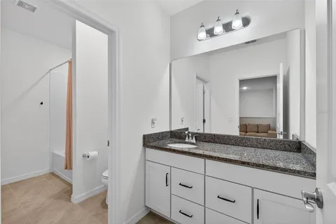 a bathroom with a granite countertop sink and a mirror