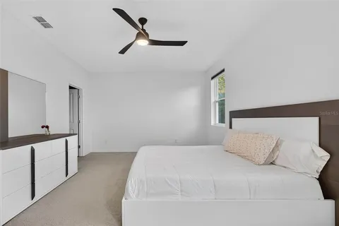 a bedroom with a large bed and a chandelier