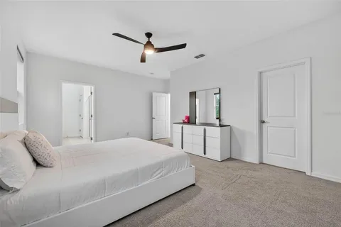 a spacious bedroom with a bed and a chandelier