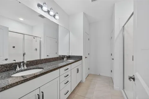 a bathroom with double sink and a mirror