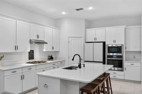 a kitchen with kitchen island a sink stove and refrigerator