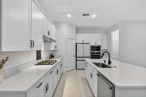a kitchen with a sink a refrigerator and cabinets
