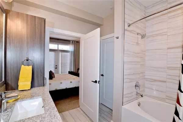 a bathroom with a tub shower and sink