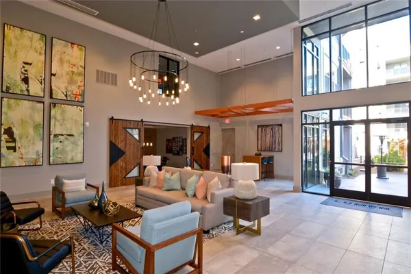a living room with furniture a chandelier and a large window