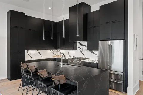 a kitchen with stainless steel appliances granite countertop a refrigerator and a sink