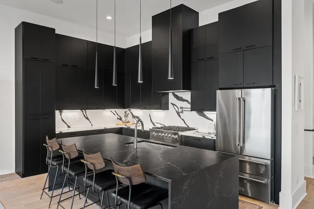 a kitchen with stainless steel appliances granite countertop a refrigerator and a sink