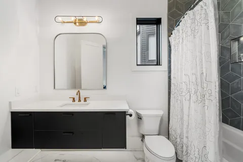 a bathroom with a sink vanity mirror and toilet