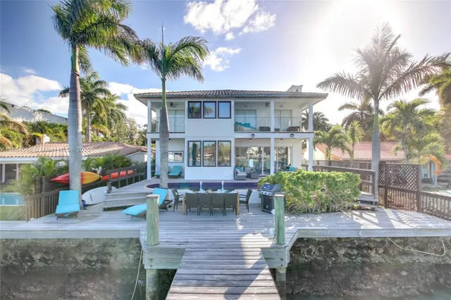 a view of a patio with couches table and chairs potted plants and palm tree