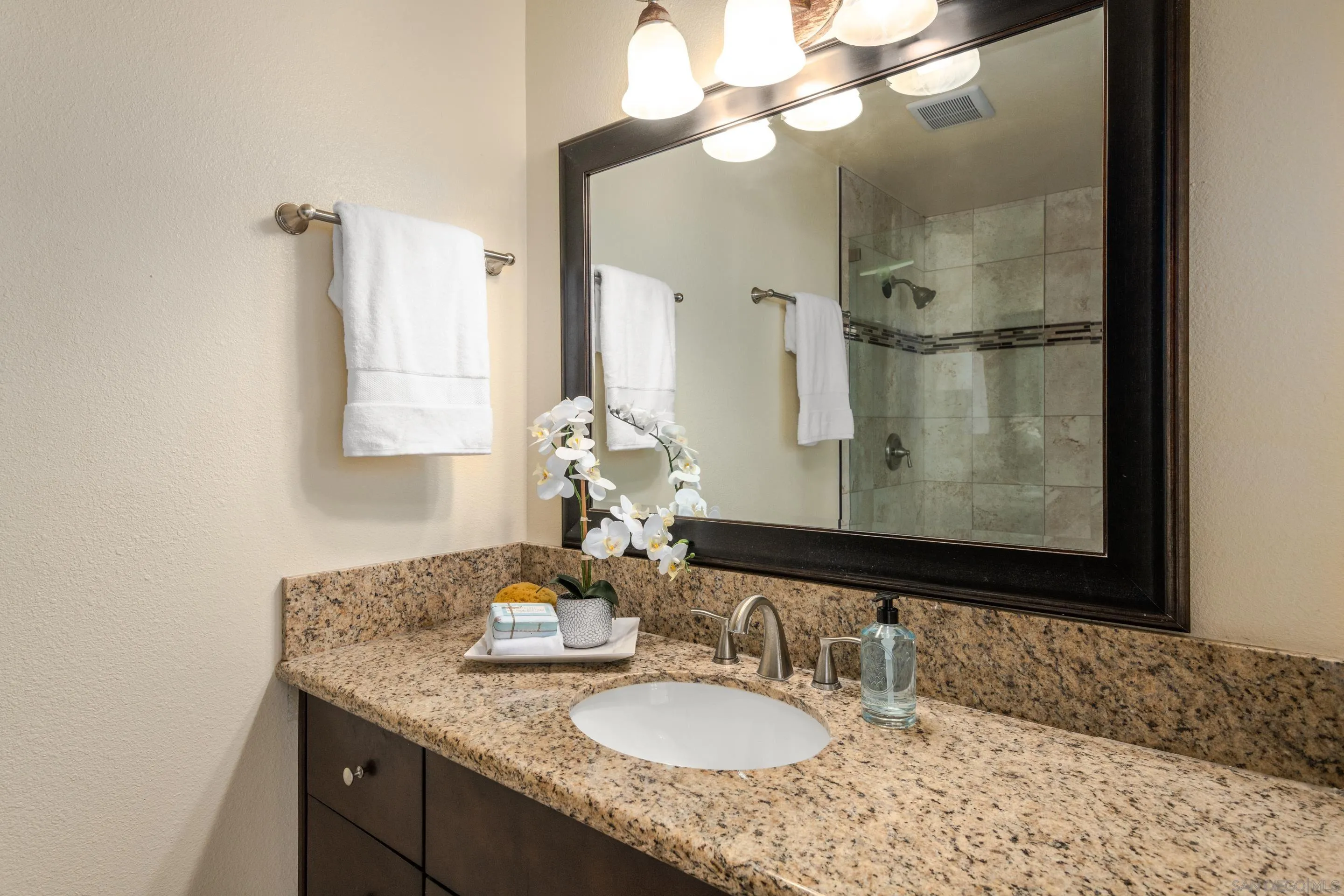 2002 Leafwood Place Encinitas, CA 92024 - Photo 23 of 64 a bathroom with a granite countertop sink a large mirror and a shower