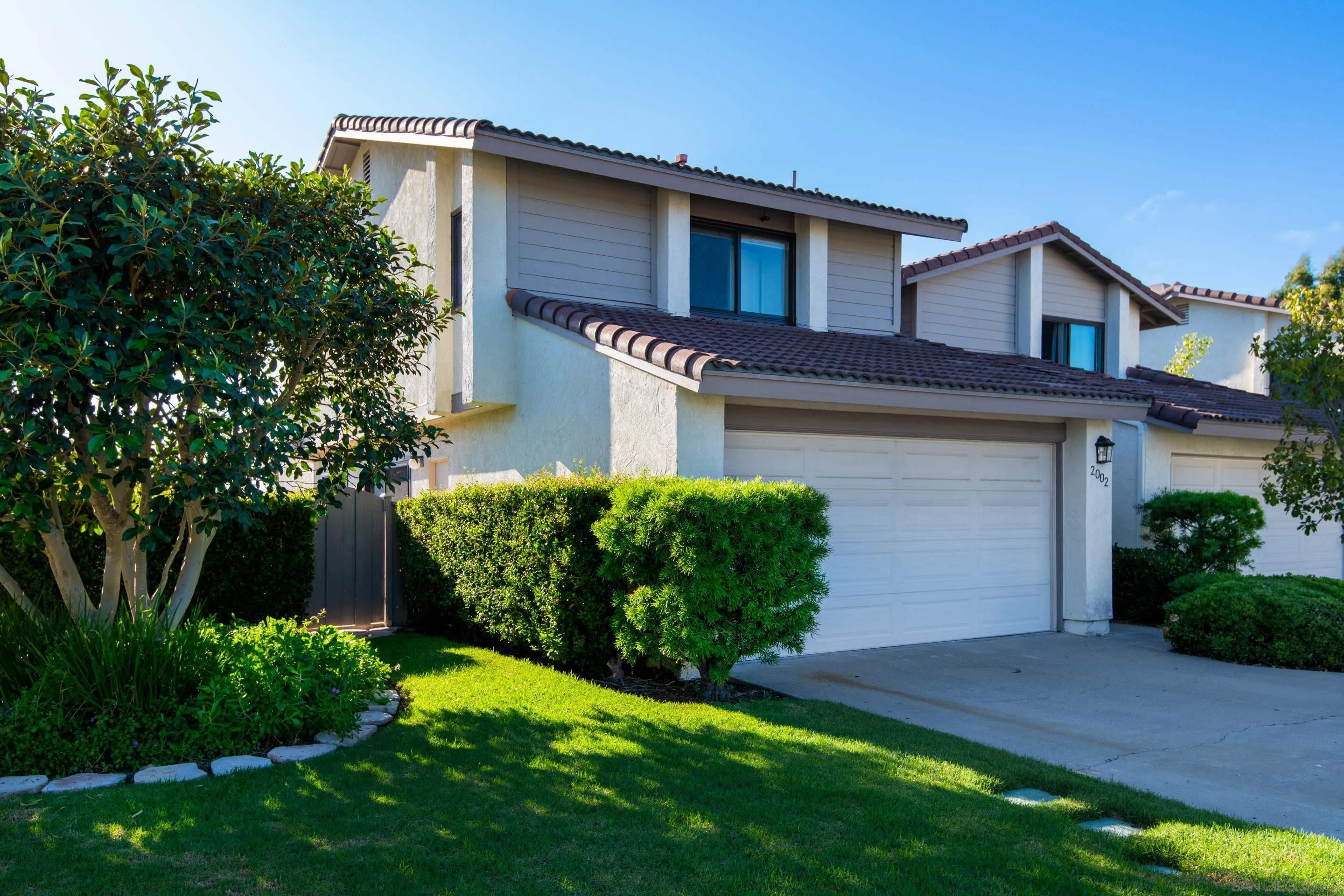 2002 Leafwood Place Encinitas, CA 92024 - Photo 46 of 64 a front view of a house with a yard and garage