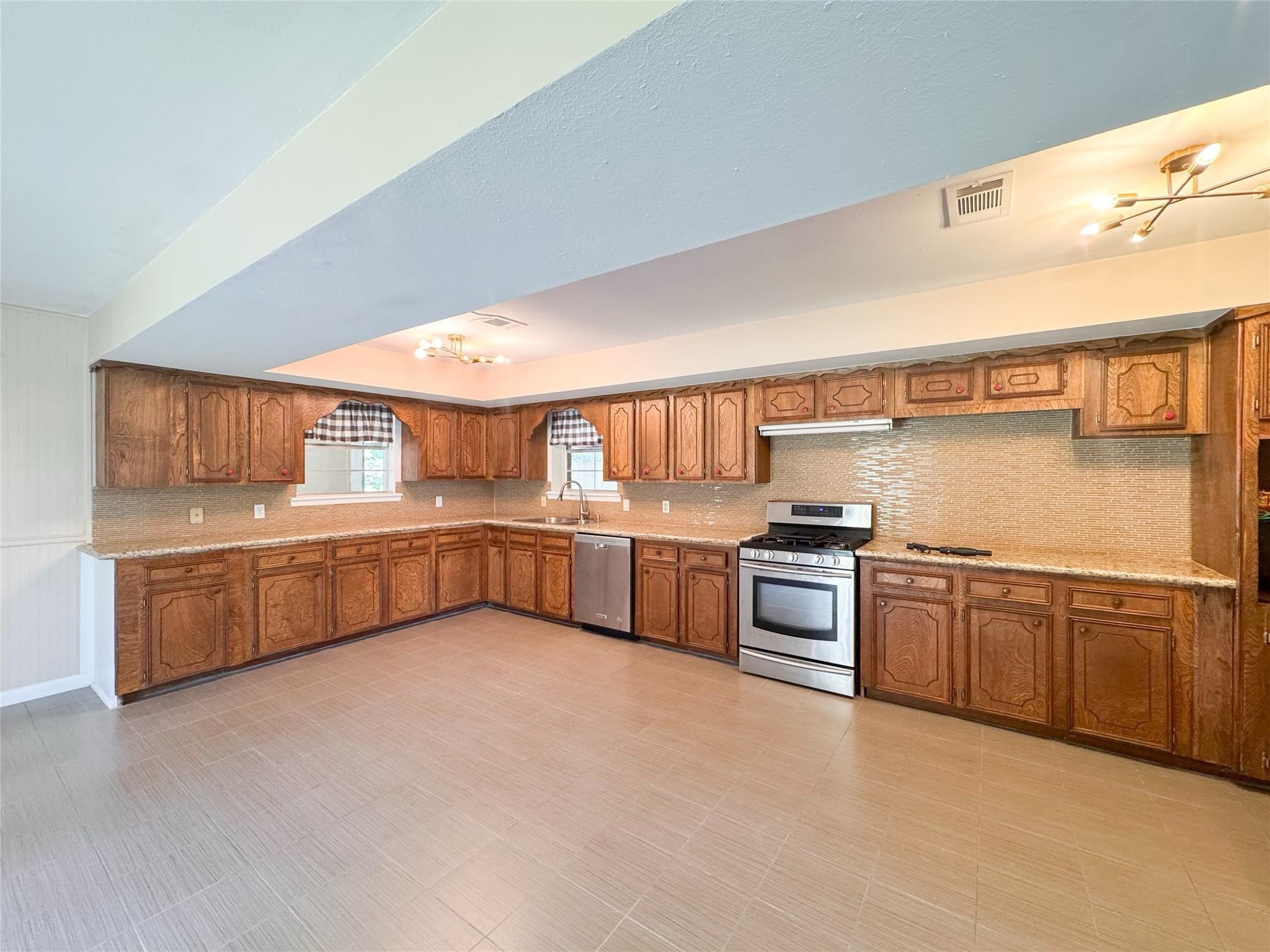 15331 Lake Lamond Road Conroe, TX 77384 - Photo 17 of 29 a kitchen with stainless steel appliances granite countertop a stove a sink and a refrigerator