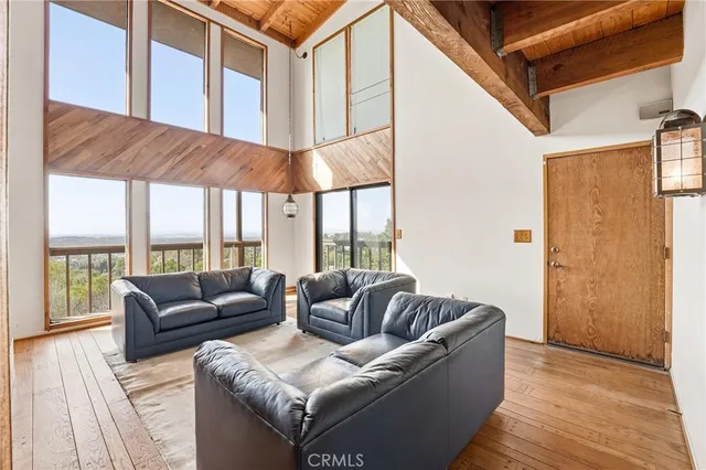 a living room with furniture a fireplace and a floor to ceiling window