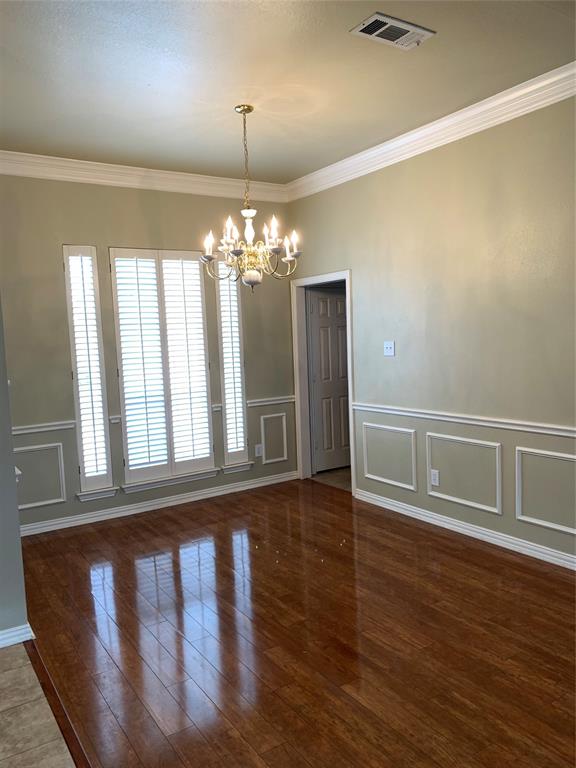 4914 Shadowood Road Colleyville, TX 76034 - Photo 23 of 28 Unfurnished dining area featuring a chandelier, a decorative wall, crown molding, wood finished floors, and wainscoting