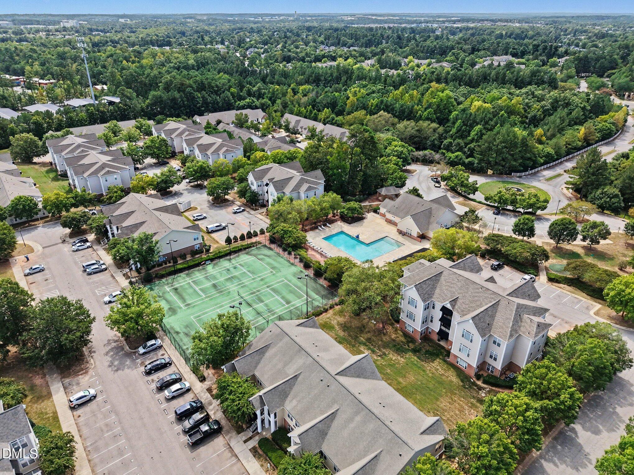 2521 Friedland Place Raleigh, NC 27617 - Photo 18 of 21 Community recreational hub featuring an outdoor swimming pool with expansive sun deck, paired with on-site tennis/pickleball courts just steps from your front door, ideal for summer lounging or staying active all year without leaving home.