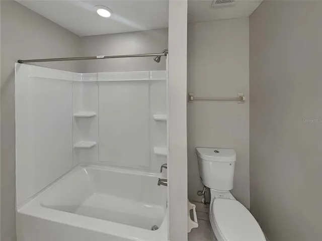 a white toilet sitting next to a bath tub