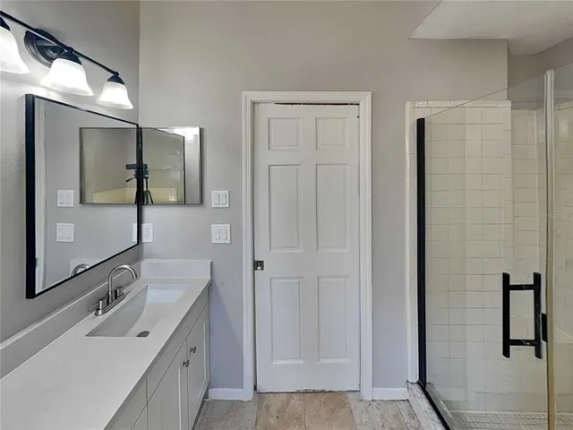 a bathroom with a double vanity sink mirror and shower