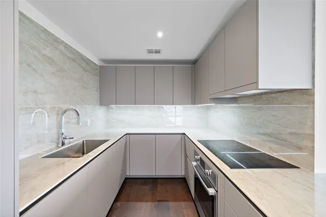 a kitchen with a sink stove top oven and cabinets