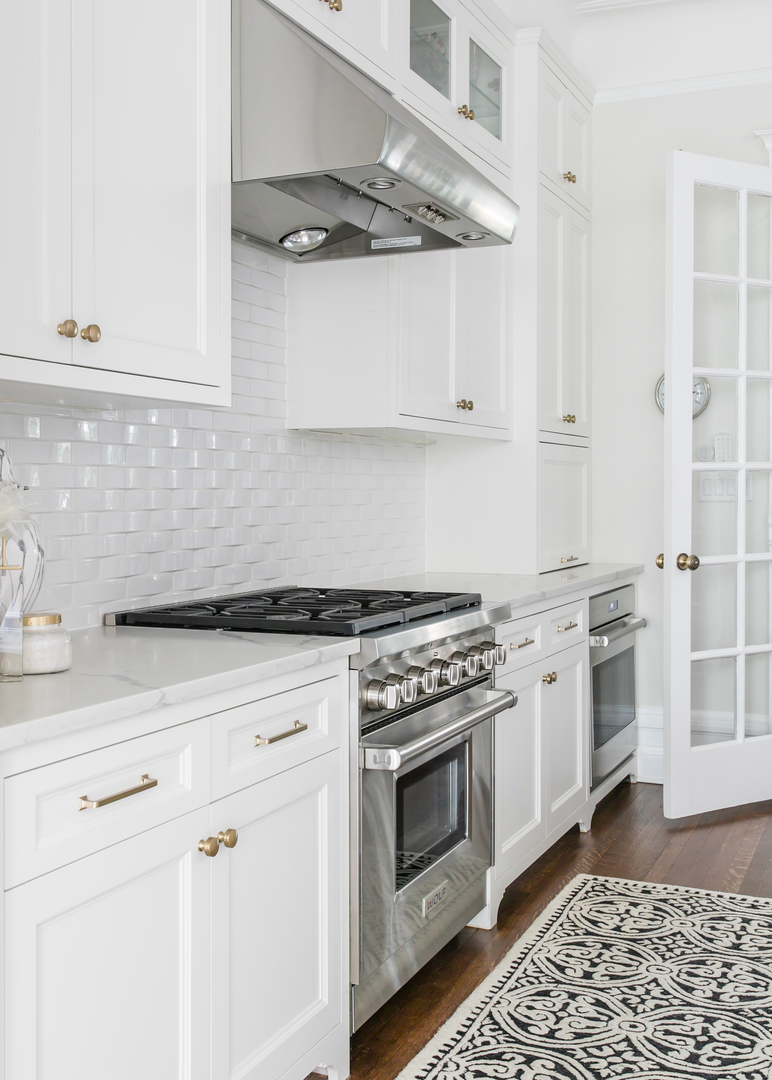 1304 North Ritchie Court Chicago, IL 60610 - Photo 19 of 39 a kitchen with stainless steel appliances white cabinets and a stove