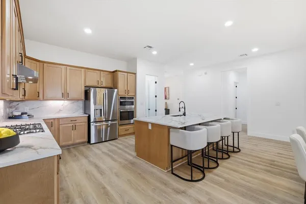 a kitchen with a table chairs refrigerator and microwave