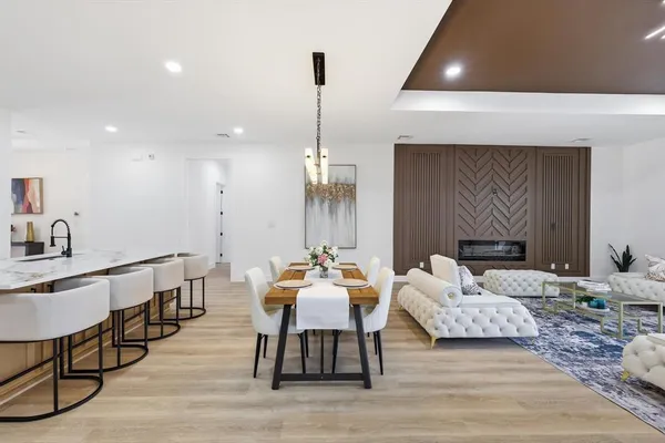 a living room with furniture a fireplace and a chandelier