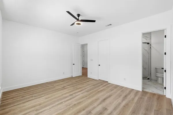 a view of a room with wooden floor and a ceiling fan