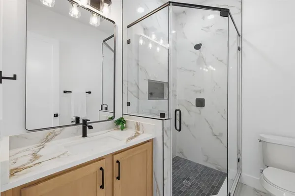 a bathroom with a granite countertop sink toilet and shower