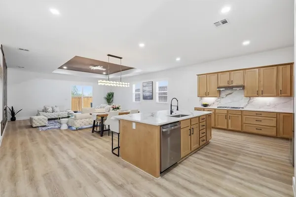 a kitchen with stove a sink and cabinets