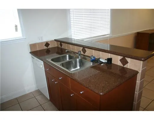 a kitchen with a sink a counter top space and a window