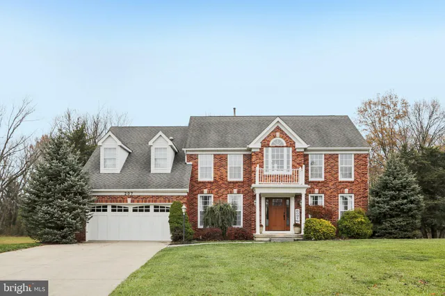a view of a big house with a big yard and large trees
