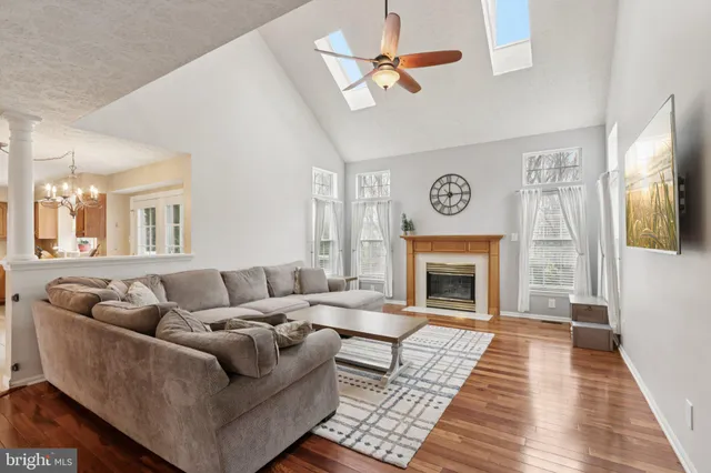 a kitchen with kitchen island granite countertop a sink dishwasher stove and refrigerator with wooden floor