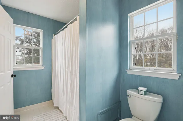 a white bath tub sitting next to a white shower curtain